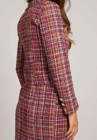 Tweed blazer in rood, roze en meerkleurig patroon met een getailleerd ontwerp. Bevat knoopaccenten op de manchetten en een notch-kraag.