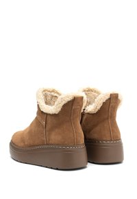 Barna velúr bokacsizmák puha krém színű műszőrmével bélelve, vastag barna platformtalppal és finom varrási részletekkel.