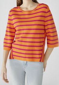 Pull rayé en orange et magenta, fabriqué en tissu doux. Doté d'un col rond et de manches trois-quarts, avec une coupe décontractée.