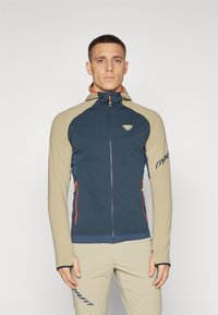 Hooded jacket featuring a navy body with beige sleeves and orange accents, two front zip pockets, and a logo on the chest.