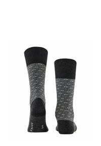 Schwarz und grau gemusterte Socken mit einem gerippten Bündchen, das ein geometrisches Design aufweist. Hergestellt aus einem weichen Material für zusätzlichen Komfort.