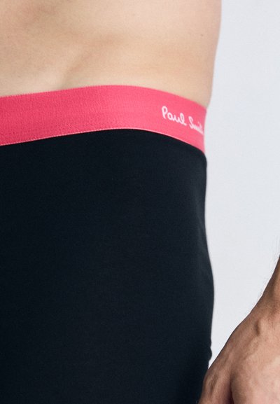 Fekete boxer alsónadrág rózsaszín rugalmas derékkal, amelyen a "Paul Smith" logó fehér színben látható. Puha, sima anyag, varrás nélküli dizájn.