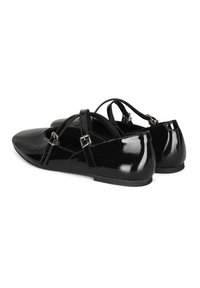 Zwarte lakleren flats met een puntige neus, kruislings banden met gespaccenten en een platte zool. Glad, glanzend textuur.