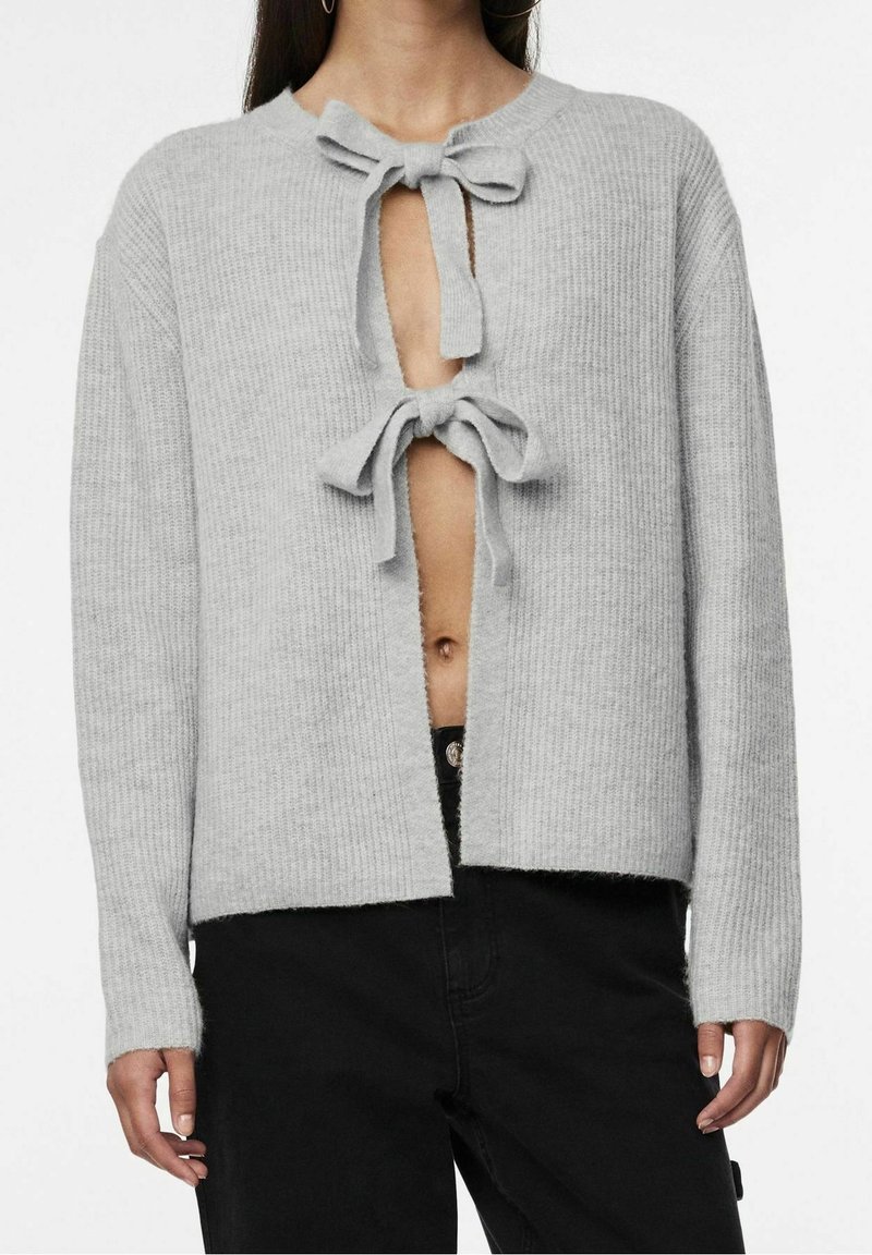 Cardigan grigio chiaro a costine con scollo a V profondo e due lacci anteriori. Maniche lunghe e vestibilità rilassata, realizzato in morbido filato a maglia.