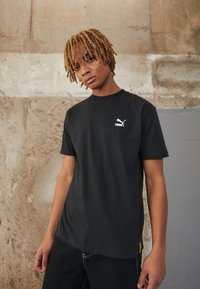 Puma PUMA STAPLE TEE - Apdrukāts T-krekls - puma black