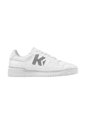 Baskets en cuir blanc avec une semelle texturée et un logo à rayures noires sur le côté. Elles présentent des lacets ronds et un design bas.