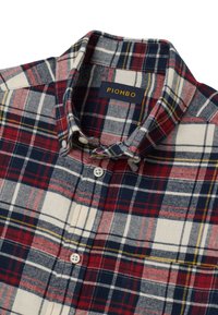 Camisa de cuadros con una combinación de colores rojo, azul marino y crema. Presenta un cuello clásico, cierre de botones en el frente y una textura de tela suave. Etiqueta: PIOMBO.