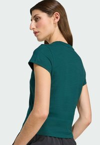 Teal short-sleeve T-shirt with a round neckline and a fitted design. Smooth cotton fabric, minimal stitching details, and a clean finish.
