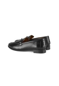 Schwarze Lederloafer mit runder Zehenform, die ein dezentes gestepptes Design und einen kleinen dekorativen Hardware-Akzent aufweisen. Flacher Absatz, glatte Textur.