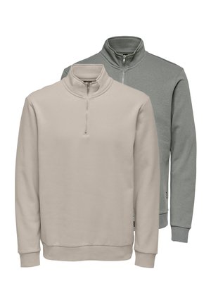 Två halvdragna sweatshirt; en i beige, en i ljusgrå. Båda har långa ärmar och ett mjukt, texturerat tyg.