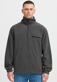 Halli hallidega hall fleece'ist pullover, millel on kõrge kaelus, pool-zip ees, rinnaosa tasku zippersiga ja küljetaskud; omadused elastsetes mansettides ja allservas.