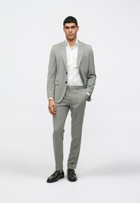 Απαλή γκρι κοστούμι ραμμένο από εκλεκτό ύφασμα, με λεπτή γραμμή, κανονικά πέ collars και μαύρα κουμπιά. Συνδυάζετε με λευκό πουκάμισο και μαύρες παπούτσια.