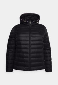 Polstret sort jakke med lynlås foran, fast hætte og justerbare snore. Har vandret quiltet mønster og diskret logo på brystet.