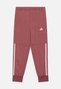 Pantalones atléticos burdeos hechos de tela suave. Presentan bolsillos laterales, rayas blancas a lo largo de los lados y puños acanalados. Logo de adidas en la cadera.