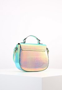 Irydyscentna torebka crossbody z teksturowanej skóry ekologicznej, o wyraźnym kształcie, metalowych akcentach i odpinanym pasku.