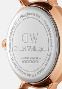Fond de montre en acier inoxydable avec surface en argent poli, texte gravé. Dispose d'une lunette de couleur or rose et d'une indication de résistance à l'eau.
