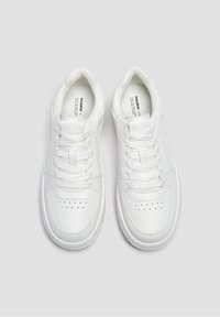 Weiße Sneakers mit einem glatten Lederobermaterial, runder Zehenform, verstärkten Nähten und flachen Schnürsenkeln. Minimale Markenkennzeichnung auf den Innensohlen sichtbar.