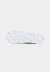 Bela gumijasta podplata čevlja z teksturiranim geometrijskim vzorcem in obliko zaobljenega spoja, ki se rahlo ukrivlja proti peti.