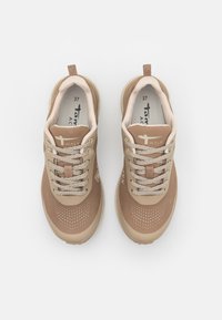 Beżowe buty do chodzenia z gładką, syntetyczną cholewką, teksturowanymi detalami i jasnoszarymi sznurówkami. Posiadają wyściełaną podeszwę i elementy brandingowe.
