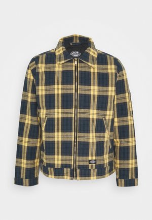 Geruite jas met gele en marineblauwe kleuren, een ritssluiting aan de voorkant, een spitse kraag en zijzakken. Gemaakt van textuurstof.