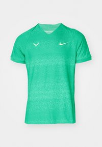 Zelena Nike sportska majica s kratkim rukavima, dizajn s V-izrezom. Sadrži teksturirani uzorak i logo akcent na lijevoj strani prsnog koša i ramenu.