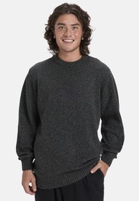 Dunkelgrauer Pullover mit strukturiertem Strick, der goldene Sprenkel aufweist, runder Ausschnitt und gerippte Bündchen sowie Saum. Lockere Passform.