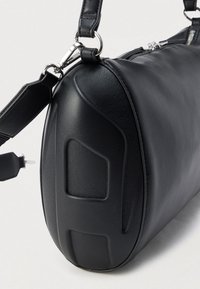 Black leather shoulder bag with a rounded shape, textured finish, and silver hardware accents. Features adjustable strap and zip closure.