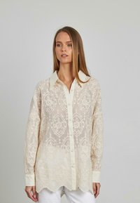 Durchsichtige cremefarbene Bluse mit gesticktem Blumenmuster, mit Kragen, Knopfverschluss, langen Ärmeln und gewelltem Saum.