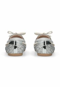 Ballerines pailletées métalliques argentées avec un nœud, devant en tissu texturé, accents argentés brillants et semelle lisse beige.