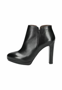 Bottine en cuir noir à talon haut, avec un bout pointu, un design avec découpes sur le côté, une texture lisse, et un subtil accent de logo métallique sur le talon.