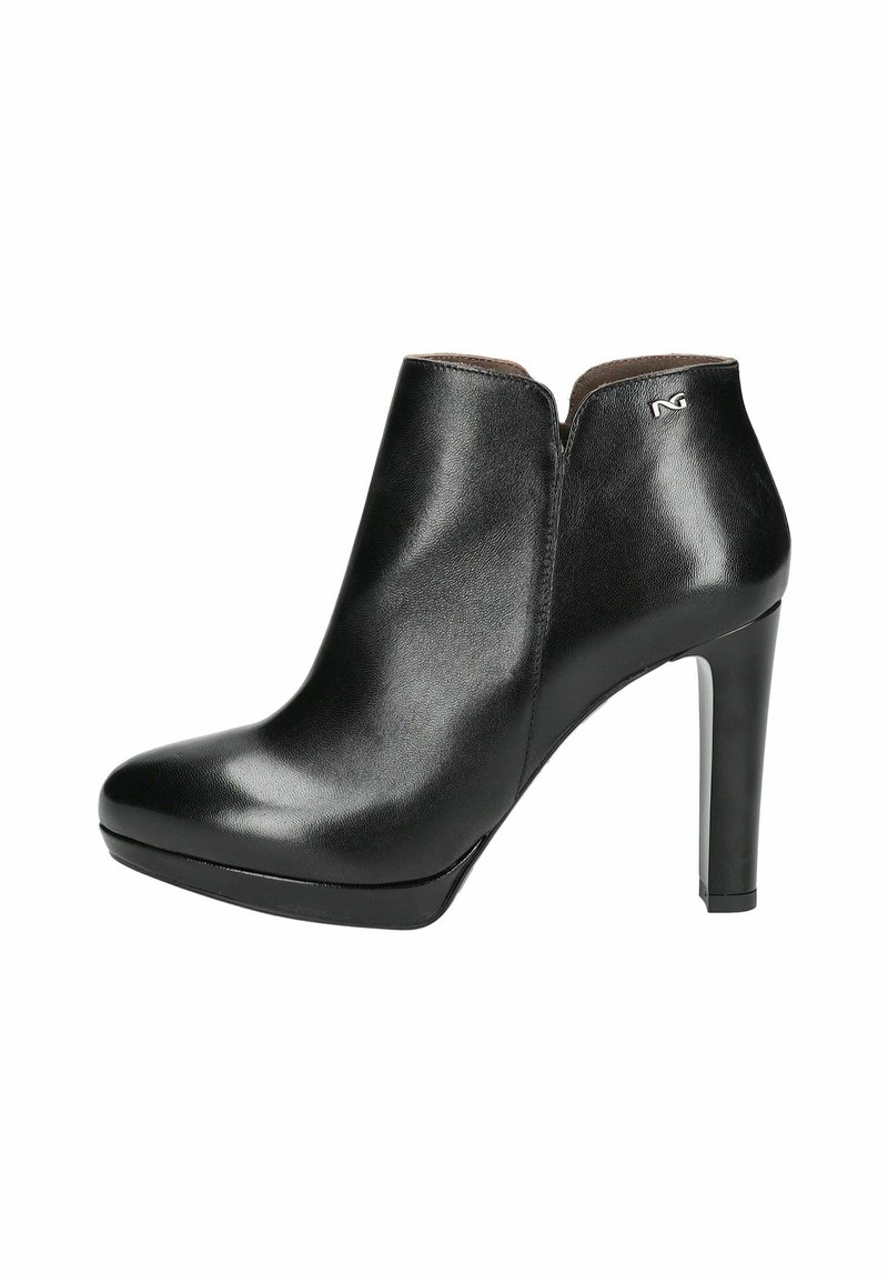 Bottine en cuir noir à talon haut, avec un bout pointu, un design avec découpes sur le côté, une texture lisse, et un subtil accent de logo métallique sur le talon.