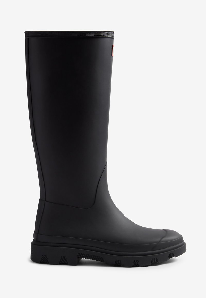 Botte de pluie en caoutchouc noir avec une surface lisse, un haut tige, une semelle à traction texturée et un subtil détail latéral, conçue pour une protection imperméable.