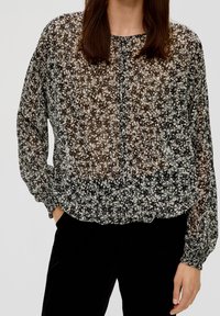 Schwarze blumenverzierte transparente Bluse mit rundem Ausschnitt, langen Ärmeln, gerafftem Saum und zarten weißen und grauen Blumenmustern.