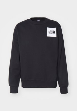 Sort sweatshirt med rund hals, ribbede manchetter og søm. Har et hvidt firkantet mærke med "THE NORTH FACE" logoet på brystet.