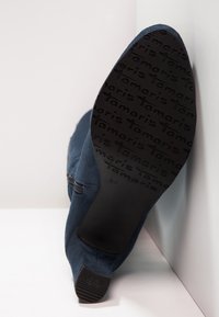 Granatowe zamszowe botki za kostkę z gumową podeszwą, z boku z zamkiem błyskawicznym oraz teksturowanym wytłoczeniem "Tamaris" na podeszwie. Rozmiar 37.