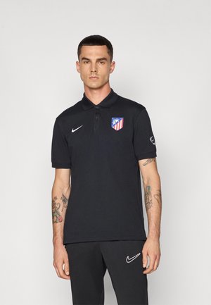 Black polo shirt with collar, featuring a red and blue Atlético Madrid logo on the chest and a white Nike swoosh on the side.
