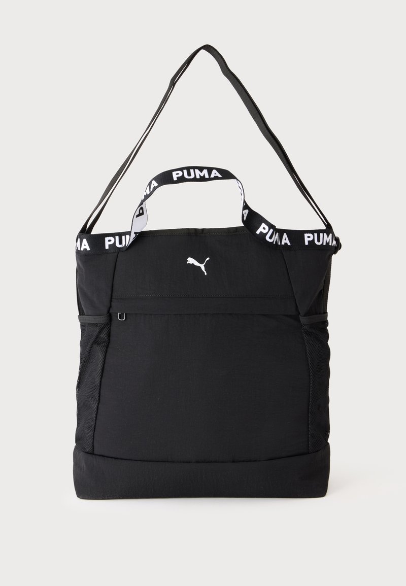 Sac tote noir Puma avec deux poignées, une bandoulière réglable, des poches latérales en mesh et un petit logo blanc Puma à l'avant.