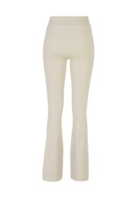 Krämfärgade utsvängda leggings i stretchigt material med hög midja och slät yta utan mönster eller detaljer.