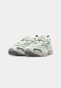 Zapatillas de running de malla y sintéticas en blanco y verde, con una parte superior texturizada, lengüeta acolchada y suela de goma con patrones de agarre.