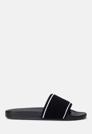 Black slide sandal with a textured rubber sole and a soft, terry cloth strap featuring white accent stripes.