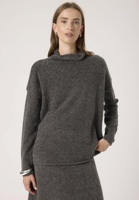 Maglione grigio antracite con collo a cascata, maniche lunghe e vestibilità ampia. Tessuto morbido e testurizzato; abbinato a una parte inferiore coordinata.