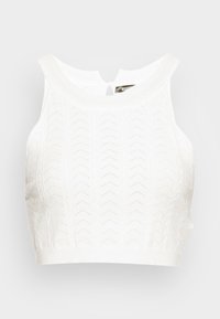 Top cropped branco feito de tecido de malha com um padrão zigzag texturizado. Apresenta um decote redondo e um pequeno detalhe em forma de olho de fechadura nas costas.