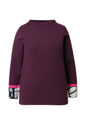 Lilla langærmet top med høj hals. Har farveblokerede manchetter i pink og mønstrede detaljer i sort og hvid.