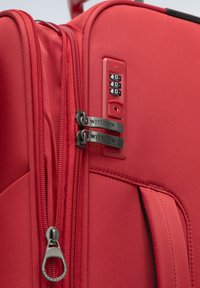 Rode koffer gemaakt van textuurstof met dubbele ritsen en 'WITTCHEN' branding, voorzien van een slotcombinatie aan de zijkant.