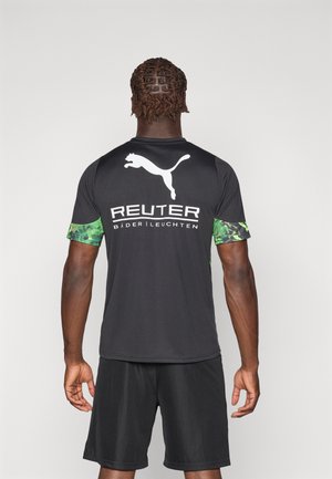 Μαύρο μπλουζάκι κοντομάνικο με μανίκια σε πράσινο καμουφλάζ, με λευκό λογότυπο Puma και κείμενο "REUTER" στην πλάτη.