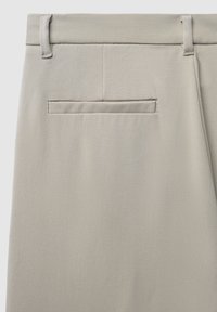 Pantaloni grigi chiari realizzati in un tessuto liscio e texturizzato. Presentano una tasca posteriore con apertura orizzontale e passanti per la cintura in vita.