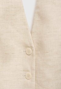 Beige linen vest featuring a V-neck design and two rounded buttons. The fabric has a textured, woven appearance.