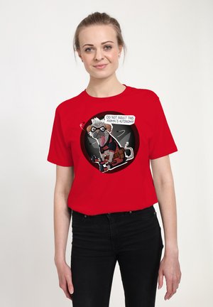Kvinde iført en rød t-shirt med en tegneserie af en mops med goggles og udstyr, med teksten "Fornærm ikke dette dyrs autonomi."
