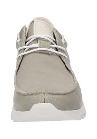 Chaussure en toile beige avec des lacets blancs, bout arrondi, semelle profil bas et détails de couture minimaux. Style à lacets et tissu texturé.