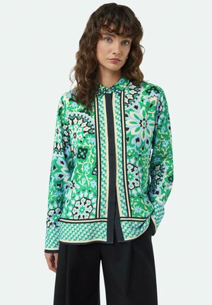 Multicolored blouse featuring floral patterns in greens and blues, with a collar, black vertical stripe, and long sleeves. Smooth texture.